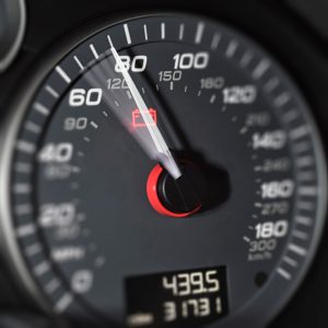 Close-up showing a rising speedometer needle moving past 70mph towards 80mph on a modern high-performance sports car.